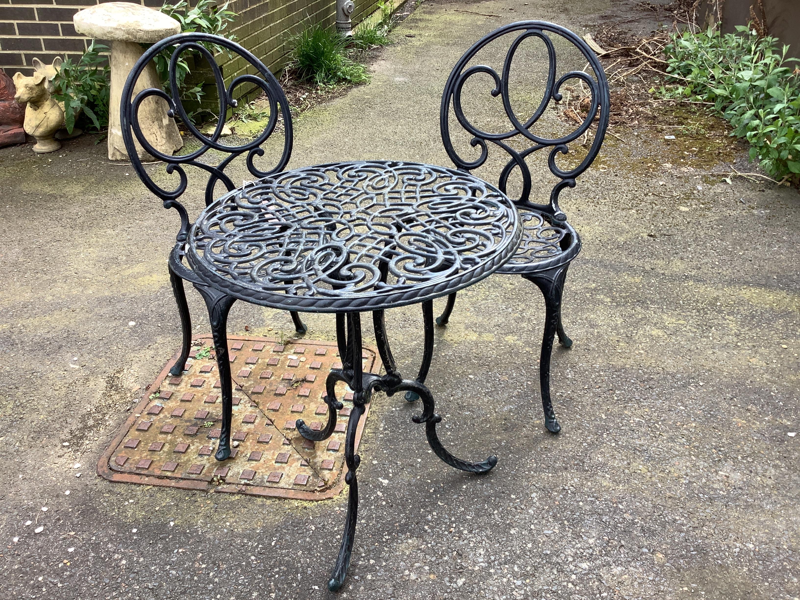 A circular painted aluminium garden table, diameter 60cm, height 70cm and two chairs